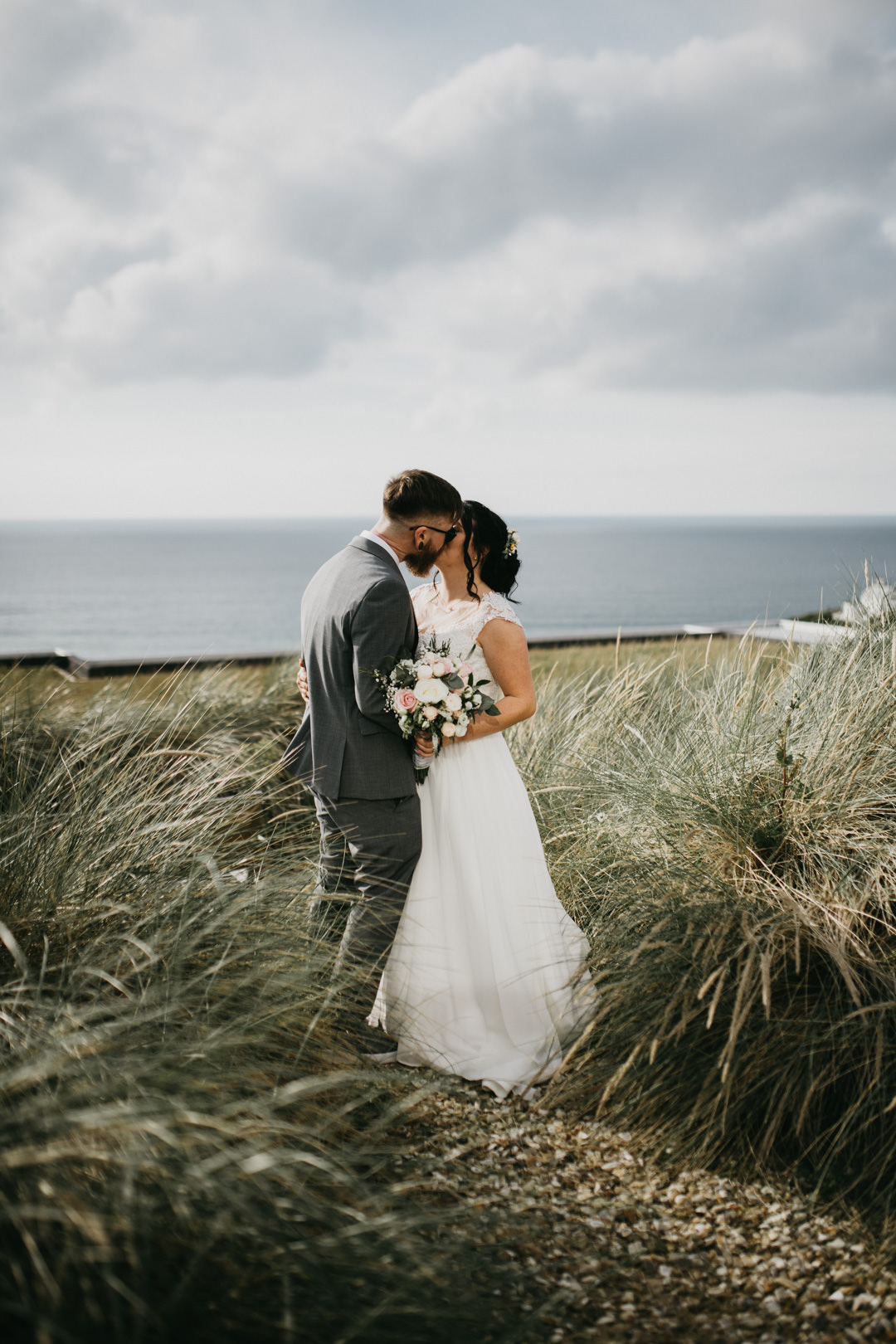 bride and groom kissing on beach